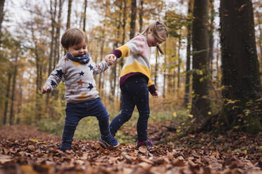 Germany, Baden-Wurttenberg, Lenningen, Two children playing in autumn forest - SEBF00276