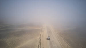 Drohnenansicht eines Geländewagens in der nebligen Wüste, Namibia - VEGF00910