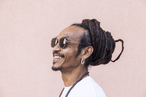 Portrait of smiling mature man with dreadlocks and sunglasses - TCF06195