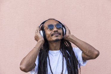 Portrait of mature man with dreadlocks and headphones, listening music - TCF06204