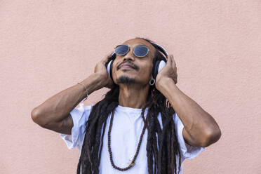 Portrait of mature man with dreadlocks and headphones, listening music - TCF06205