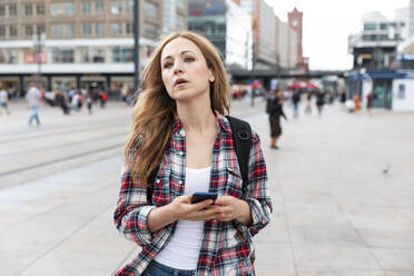 Frau mit Smartphone in der Stadt, Berlin, Deutschland - WPEF02297