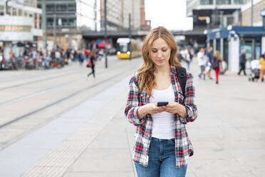 Frau mit Smartphone in der Stadt, Berlin, Deutschland - WPEF02298