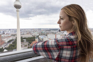 Woman looking at view of the city with television tower, Berlin, Germany - WPEF02302