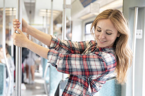 Glückliche Frau in der U-Bahn, Berlin, Deutschland - WPEF02311