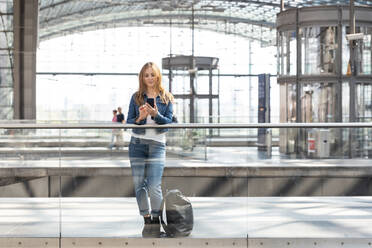 Frau mit Smartphone auf dem Bahnhof, Berlin, Deutschland - WPEF02317