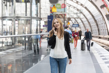 Frau am Telefon auf dem Bahnsteig, Berlin, Deutschland - WPEF02336