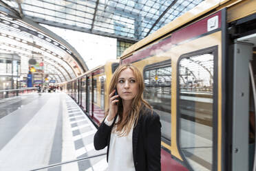 Woman on the phone getting off the train, Berlin, Germany - WPEF02337