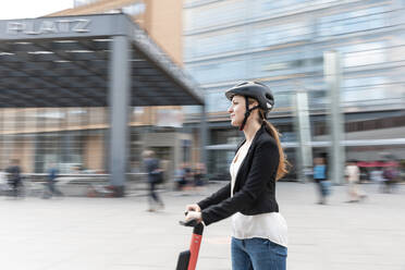 Frau fährt E-Scooter in der Stadt, Berlin, Deutschland, Berlin, Deutschland - WPEF02338