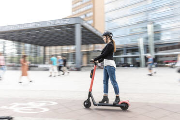 Frau fährt E-Scooter in der Stadt, Berlin, Deutschland, Berlin, Deutschland - WPEF02339