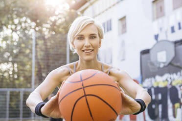 Blonde woman playing basketball in Cologne, Germany - MADF01404