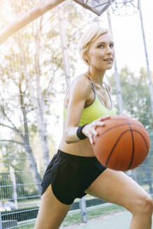 Blonde Frau spielt Basketball, dribbelt - MADF01417