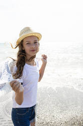 Smiling girl with towel on the beach, Tuscany, Italy - OJF00354