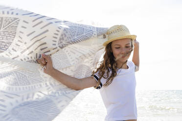 Lächelndes Mädchen mit Handtuch am Strand, Toskana, Italien - OJF00355