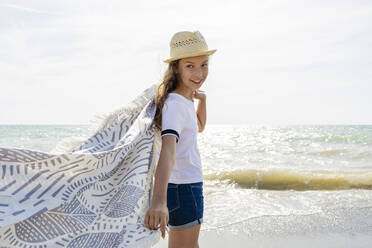 Lächelndes Mädchen mit Handtuch am Strand, Toskana, Italien - OJF00357