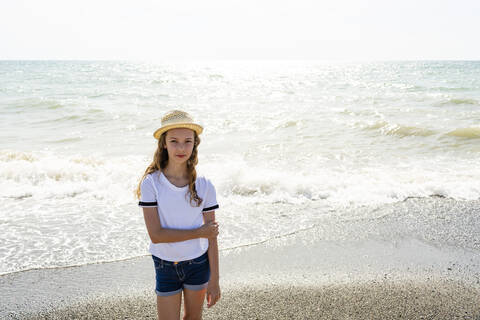 Mädchen mit Strohhut am Strand, Toskana, Italien, lizenzfreies Stockfoto