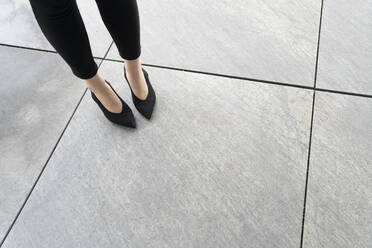 Blick auf die Beine der Frau mit Schuhen auf dem Boden - AHSF01524