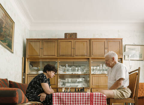 Älteres Paar spielt zu Hause Schach, lizenzfreies Stockfoto