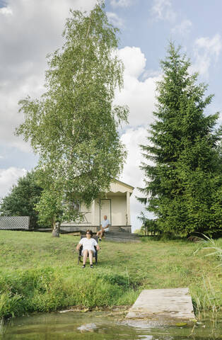 Älteres Paar entspannt sich vor seinem Ferienhaus, Kalvene, Lettland, lizenzfreies Stockfoto