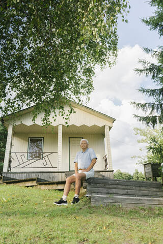 Porträt eines älteren Mannes, der sich vor seinem Ferienhaus entspannt, Kalvene, Lettland, lizenzfreies Stockfoto
