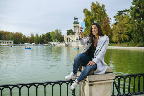 Frau macht ein Selfie im El Retiro Park, Madrid, Spanien - KIJF02840