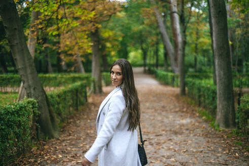 Porträt einer Frau, die in einem Park spazieren geht - KIJF02844