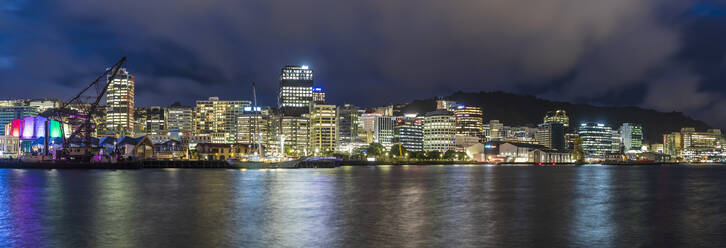 New Zealand, Wellington, Panorama of illuminated waterfront city skyline at night - FOF11263