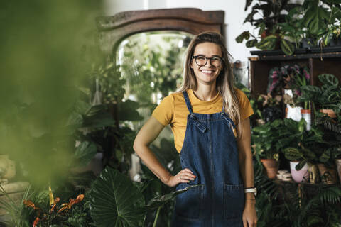 Portrait of a happy young woman in a small gardening shop stock photo