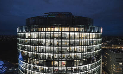 Blick auf beleuchtetes modernes Bürogebäude bei Nacht, Potsdamer Platz, Berlin, Deutschland - AHSF01574