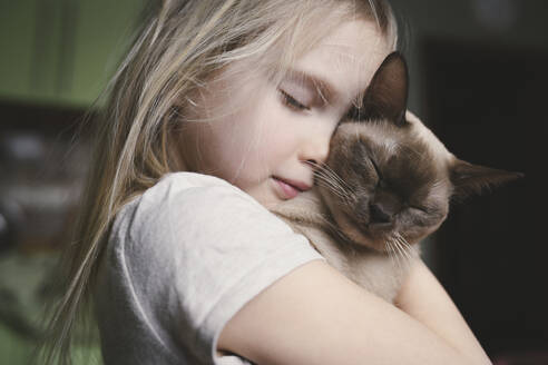 Little girl cuddling with her Burma cat - EYAF00714