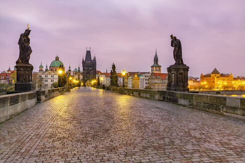 Tschechische Republik, Prag, Beleuchtete Karlsbrücke in der Morgendämmerung - YRF00216