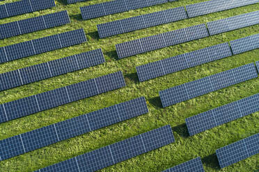 Bayern, Deutschland, Reihen von Solarmodulen auf Gras angeordnet - RUEF02383