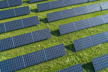 Bayern, Deutschland, Reihen von Solarmodulen auf Gras angeordnet - RUEF02384