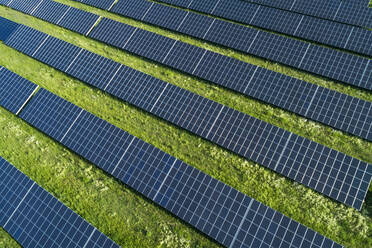 Bavaria, Germany, Rows of solar panels arranged on grass - RUEF02385