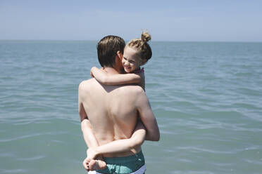 Vater trägt seine kleine Tochter am Meer - EYAF00723