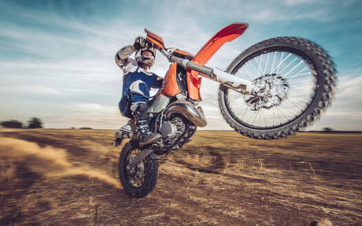 Motocross driver performing wheelie - MTBF00239