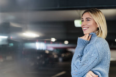 Portrait of a smiling young woman in a parking garage stock photo