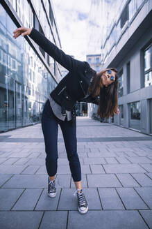 Women with sunglasses in urban location, posing artistically - DHEF00003