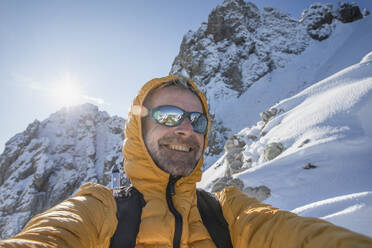 Selfie of a happy mountaineer on snowy mountain, Lecco, Italy - MCVF00086