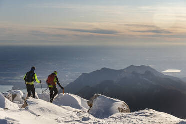 Mountaineers hiking on snowy mountain, Lecco, Italy - MCVF00091