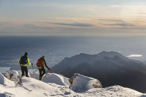 Bergsteiger beim Wandern auf einem verschneiten Berg, Lecco, Italien - MCVF00091