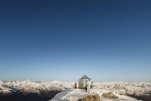 Bergsteiger, der auf dem Gipfel eines verschneiten Berges steht und die Aussicht genießt, Lecco, Italien - MCVF00093