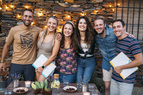 Gruppenbild von glücklichen Freunden im Freien an einem Steinhaus, lizenzfreies Stockfoto