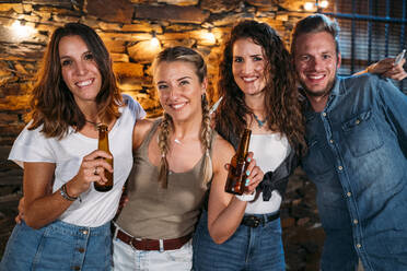 Group portrait of happy friends outdoors at a stone house having a party - MPPF00371