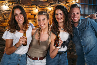Gruppenbild von glücklichen Freunden, die im Freien in einem Steinhaus eine Party feiern - MPPF00371