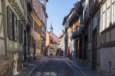 Deutschland, Sachsen-Anhalt, Quedlinburg, Kopfsteinpflaster-Gasse zwischen den Häusern der historischen Stadt - RUNF03480