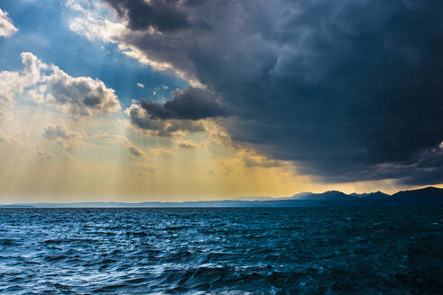 Italien, Provinz Verona, Lazise, Graue Gewitterwolken schweben in der Abenddämmerung über dem Gardasee - MHF00516