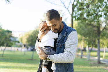 Father carrying his baby son in the park - ERRF02224