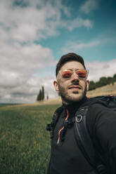 Porträt eines jungen Wanderers mit rot verspiegelter Brille - MTBF00243