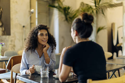 two girlfriends meeting and talking in a bistro stock photo